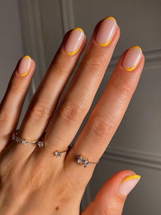 Yellow French manicure on nail with reversed details