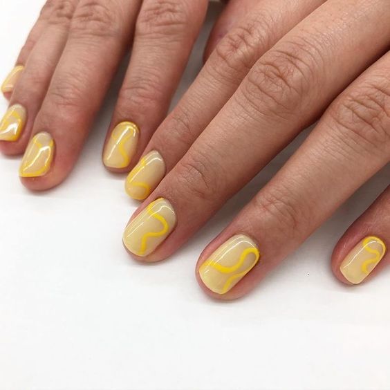 Laminated yellow nails on a light yellow base