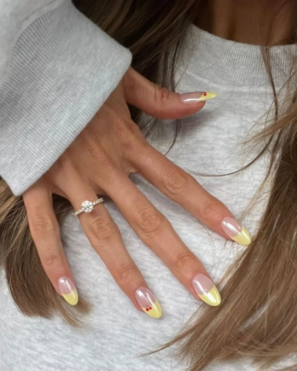 Yellow French tips of nails with chrome and cherry details