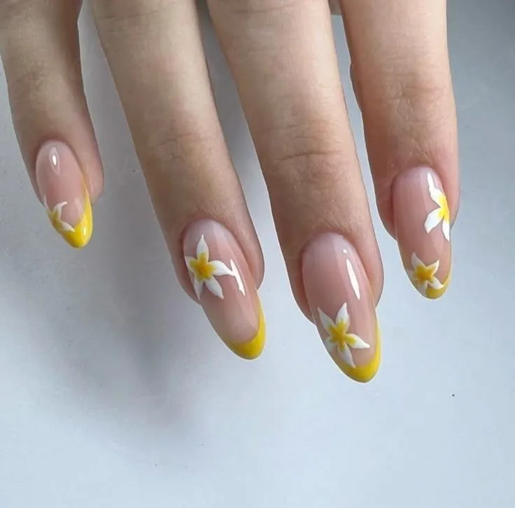 Bright yellow French tip nails with accents